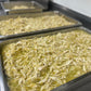 Two trays of shredded chicken in a kitchen setting
